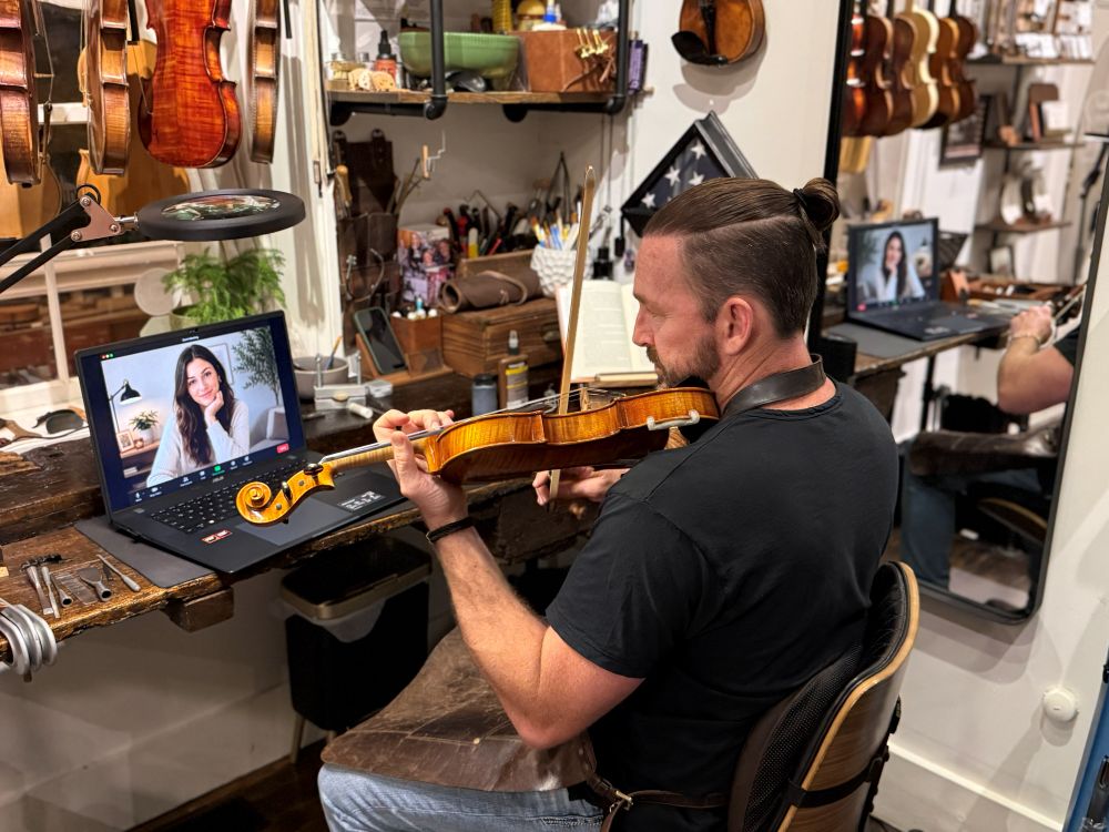 Adult female buying a violin online during a virtual appointment with the violin gallery.