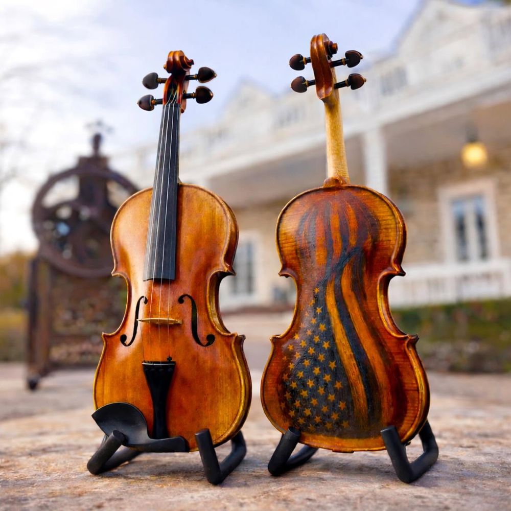 Front of Violin and Back of Violin showing burned American Flag in the back. Violin is in front of the Violin Gallery Shop