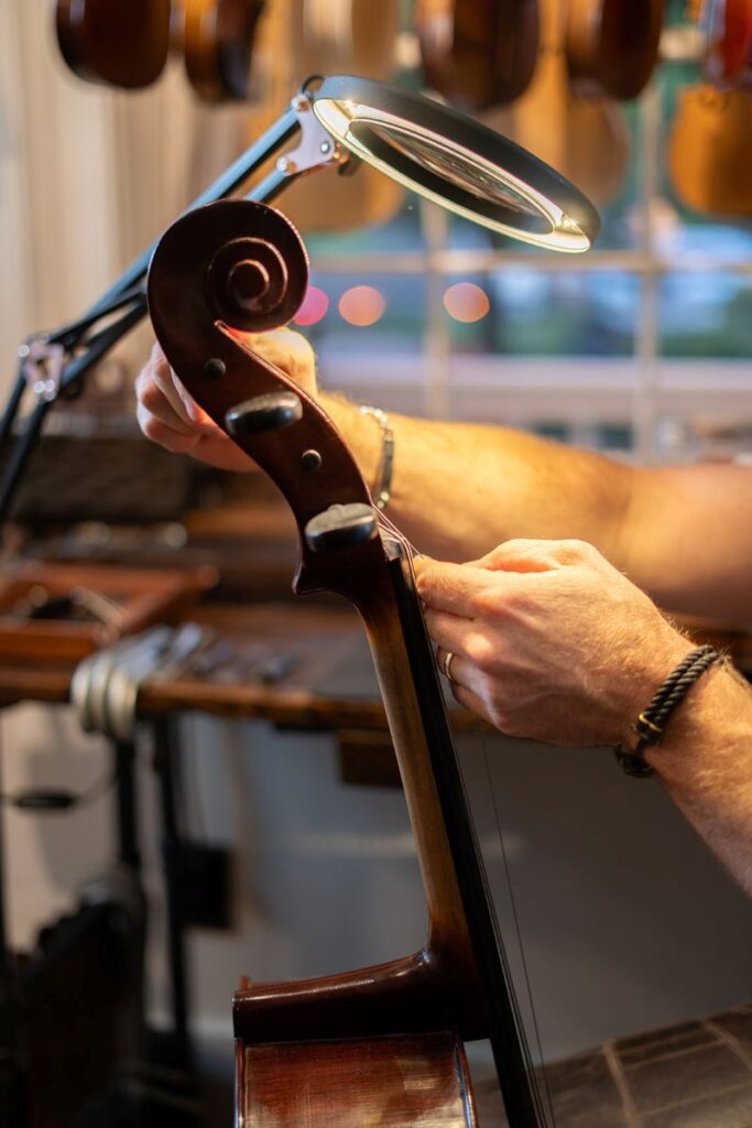 Music Store properly setting up cello.
