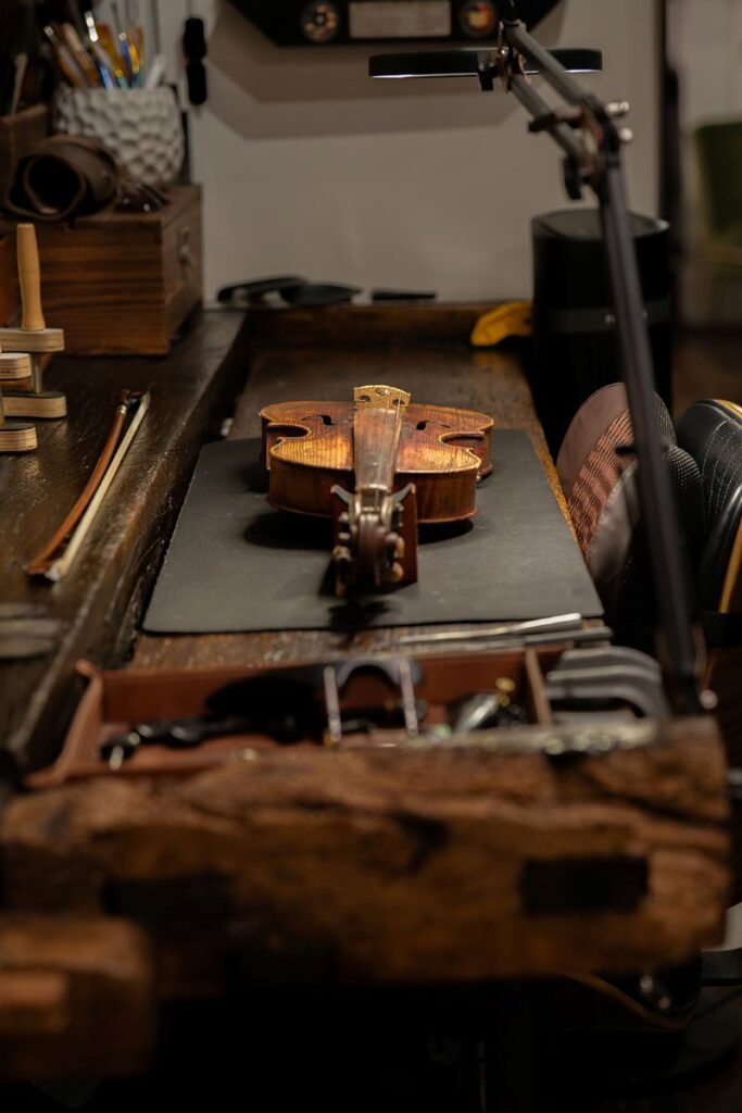 Violin sitting on luthier desk for restoration project.