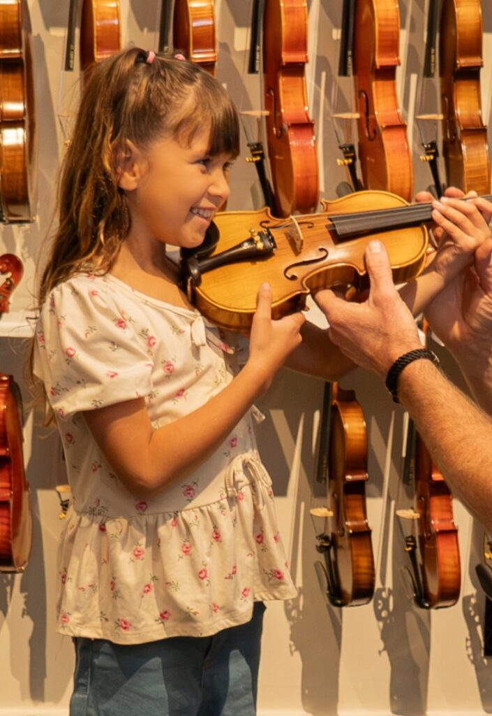 Girl trying out a violin instrument.