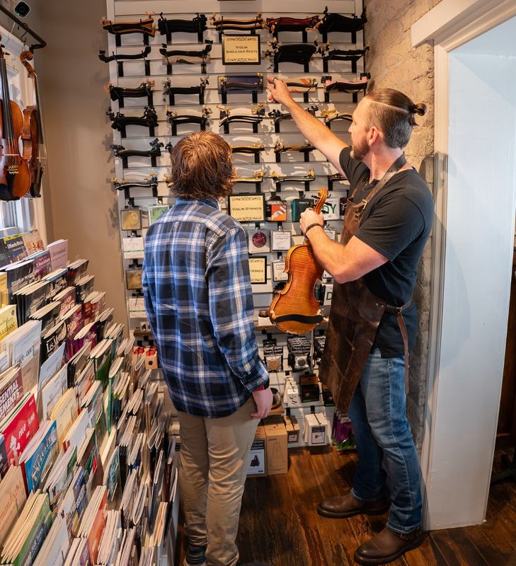 Violin Player looking for shoulder rest in music shop in St George Utah.