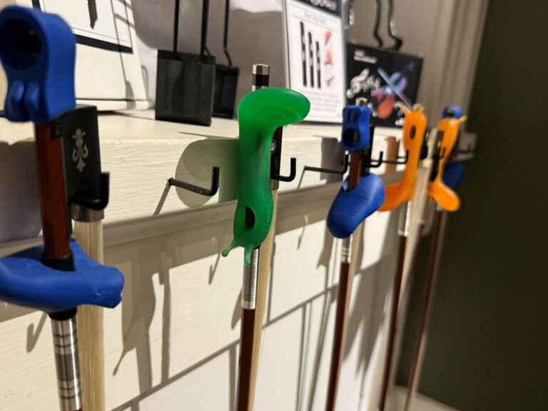 Violin bow grips on multiple violins in shop.